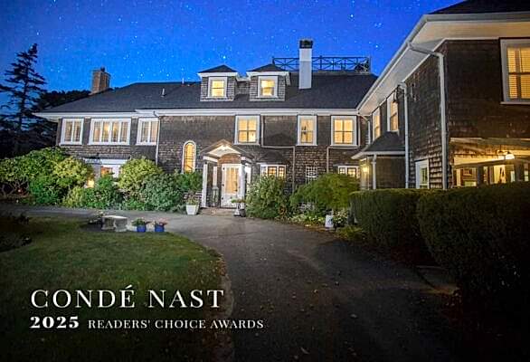 The exterior of the arts and crafts style Nobnocket Inn with starry night and Condé Nast 2025 Reader's Choice Award overlay