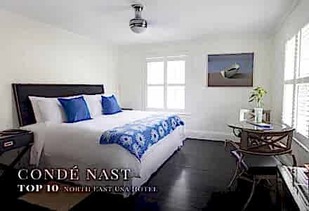 B&B room with blue pillows and comfy bed with Condé Nast Top 10 USA Hotels North East award overlay